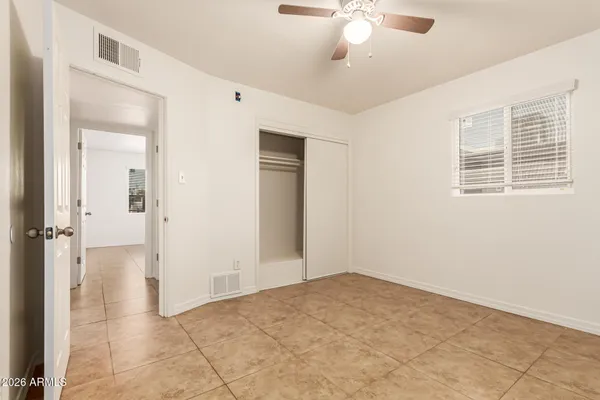 an empty room with fan and entrance