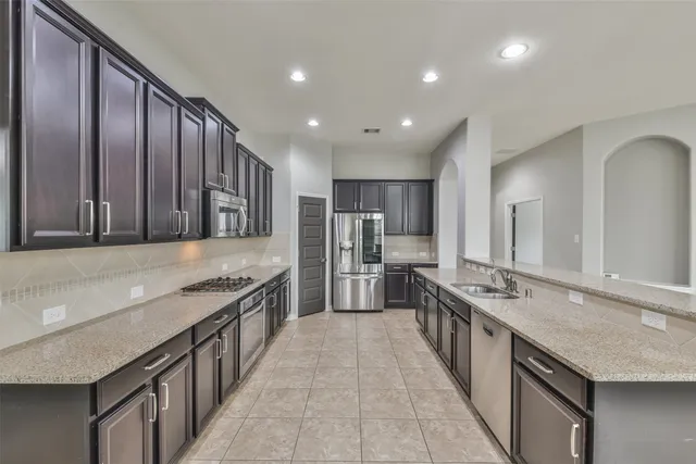 a large kitchen with stainless steel appliances granite countertop plenty wooden cabinets