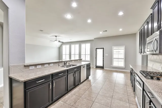 a kitchen with granite countertop cabinets stainless steel appliances and a counter space