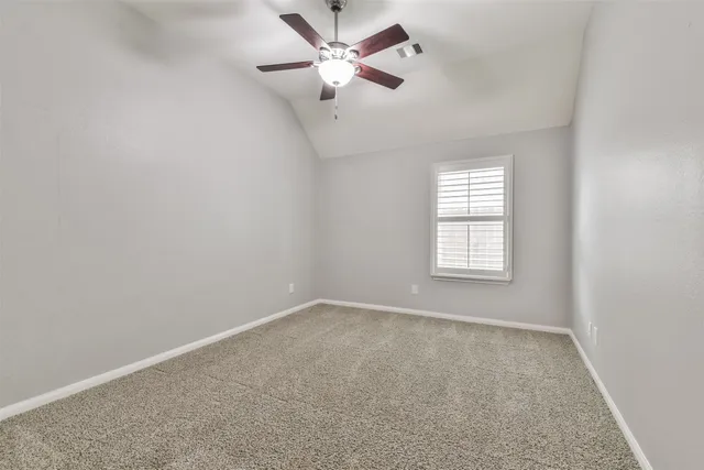 an empty room with closet and a ceiling fan