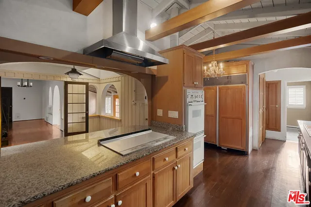 a kitchen with stainless steel appliances granite countertop a sink and wooden floors