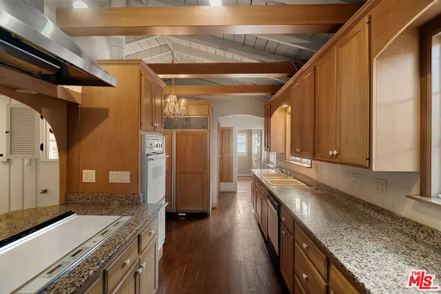 a kitchen with stainless steel appliances granite countertop a sink and wooden cabinets