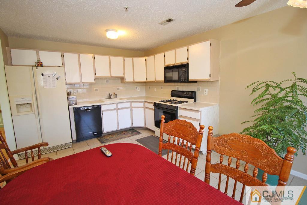 37 Inverness Drive Edison, NJ 08820 - Photo 13 of 25 a kitchen with stainless steel appliances granite countertop a refrigerator a stove top oven a sink dishwasher and white cabinets with wooden floor