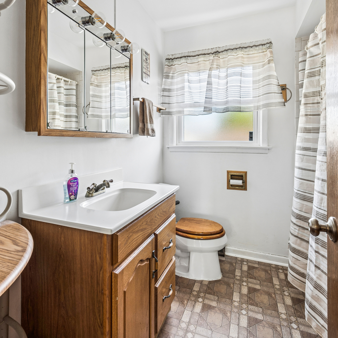 8330 Gross Point Road Morton Grove, IL 60053 - Photo 17 of 22 a bathroom with a sink toilet vanity and window