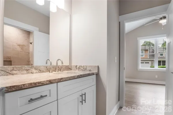 a bathroom with a granite countertop sink and a mirror