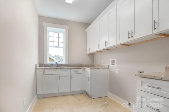 a kitchen with white cabinets and sink