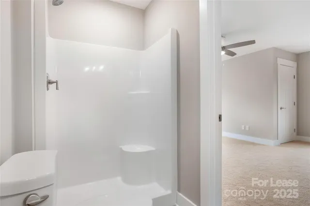 a bathroom with a granite countertop shower and a toilet