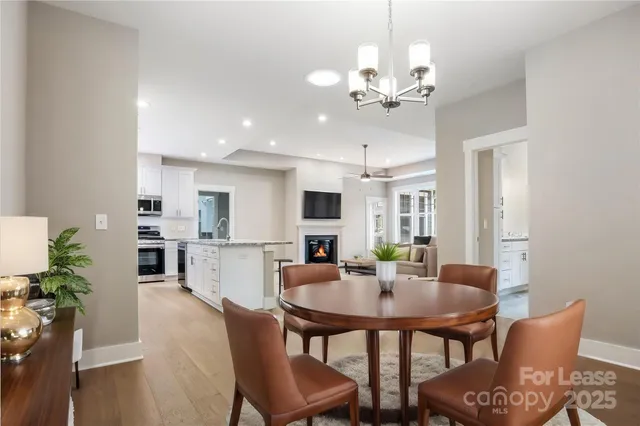 a dining room with furniture potted plants and wooden floor