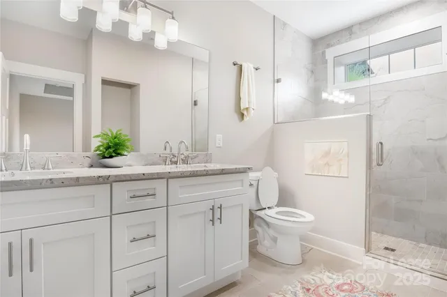 a bathroom with a granite countertop sink a toilet and a mirror