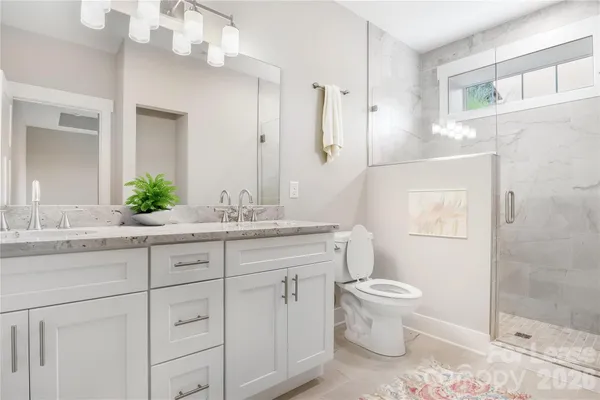 a bathroom with a granite countertop sink a toilet and a mirror