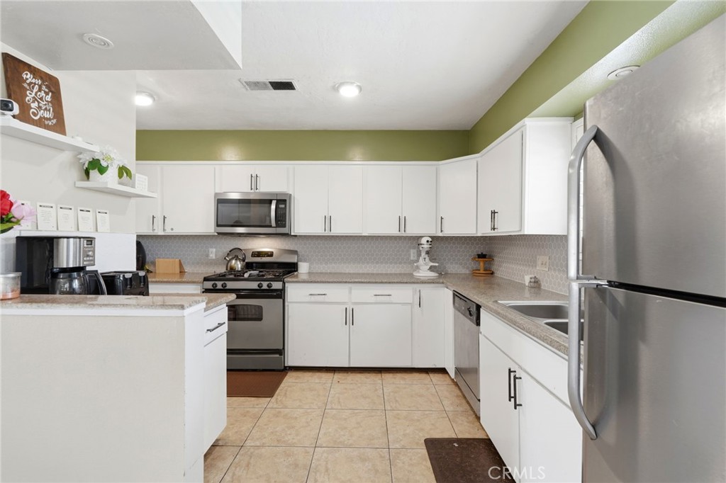1237 South Clover Street Visalia, CA 93277 - Photo 13 of 30 a kitchen with stainless steel appliances granite countertop a refrigerator sink and stove
