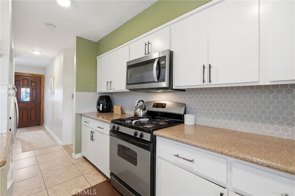 1237 South Clover Street Visalia, CA 93277 - Photo 15 of 30 a kitchen with stainless steel appliances granite countertop a sink and a stove