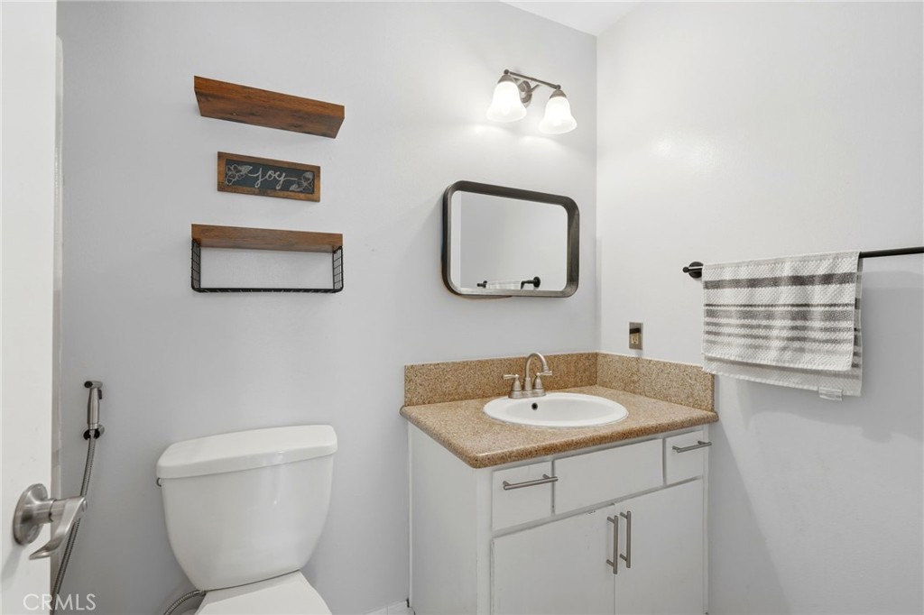 1237 South Clover Street Visalia, CA 93277 - Photo 22 of 30 a bathroom with a toilet sink and mirror