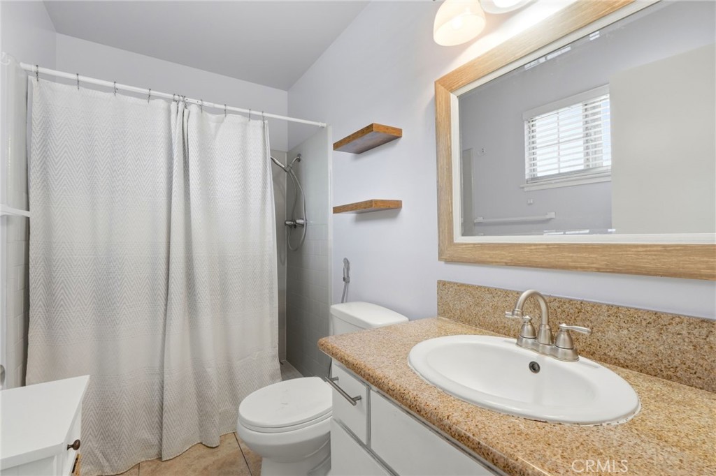 1237 South Clover Street Visalia, CA 93277 - Photo 23 of 30 a bathroom with a granite countertop sink a toilet and a mirror