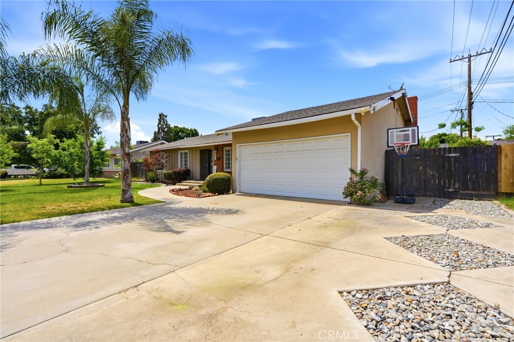1237 South Clover Street Visalia, CA 93277 - Photo 3 of 30 a front view of a house with a yard and garage