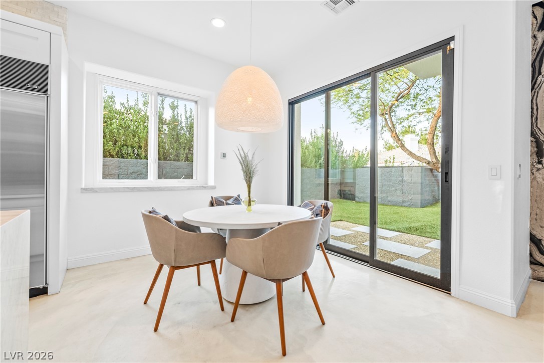 2000 Grouse Street Las Vegas, NV 89134 - Photo 20 of 89 A well-lit dining area featuring a modern light fixture and direct access to a manicured private yard.
