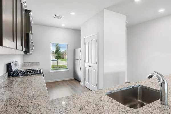 a kitchen with a sink a refrigerator and a stove