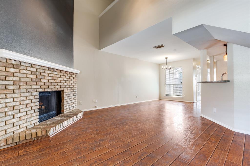 5565 Preston Oaks Road, Unit 237 Dallas, TX 75254 - Photo 4 of 14 a view of an empty room with wooden floor fireplace and a window