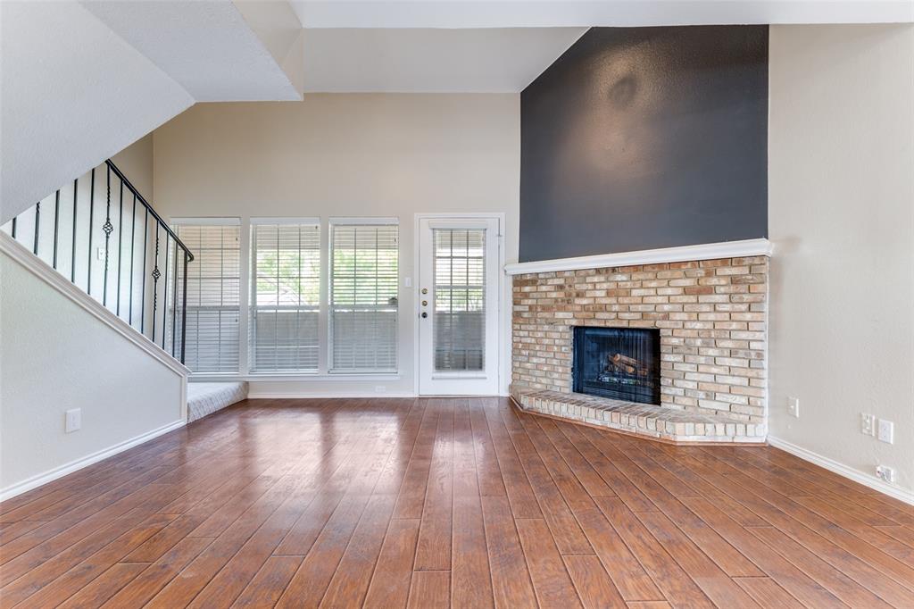 5565 Preston Oaks Road, Unit 237 Dallas, TX 75254 - Photo 6 of 14 a view of an empty room with wooden floor and a fireplace