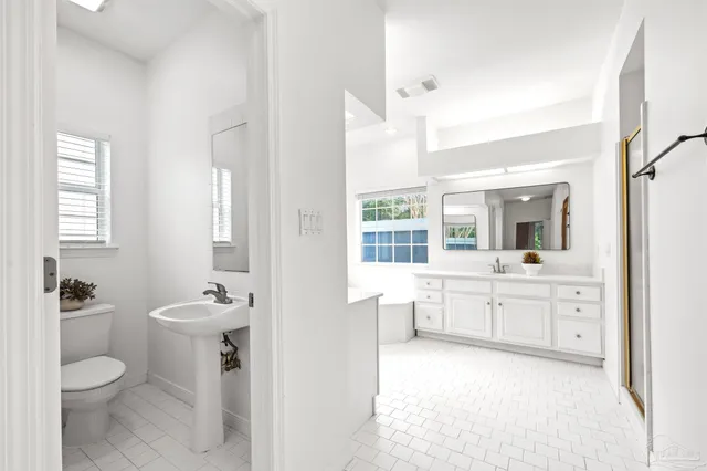 a view of an empty room with chandelier fan and a window