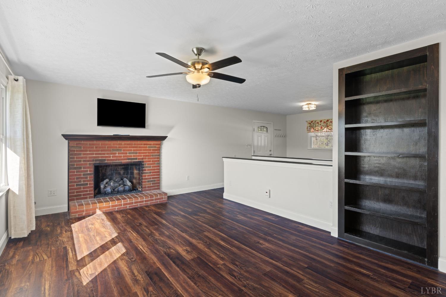 1088 Foster Road Thaxton, VA 24174 - Photo 6 of 92 a living room with a fireplace and a ceiling fan