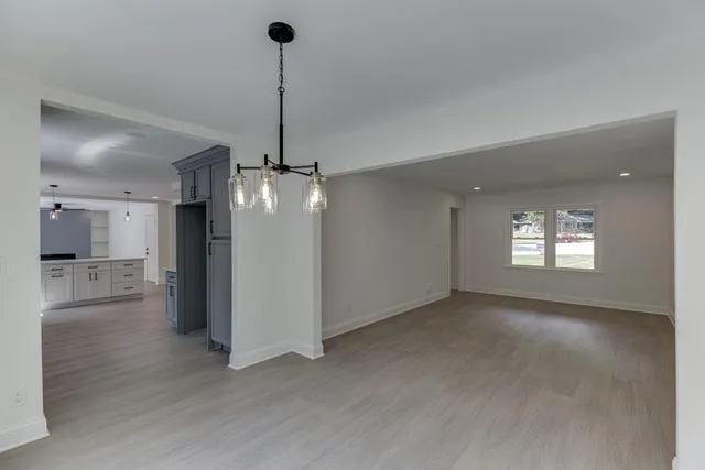 a living room with furniture a chandelier and a table