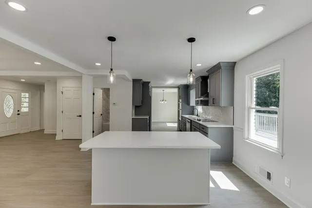 an empty room with wooden floor and ceiling fan