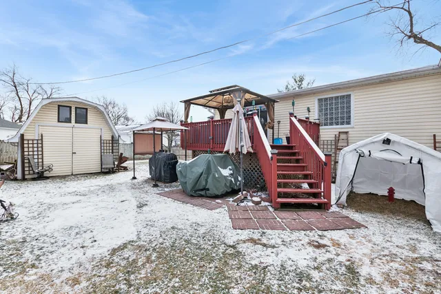 a view of a white house that has a tree in front of it