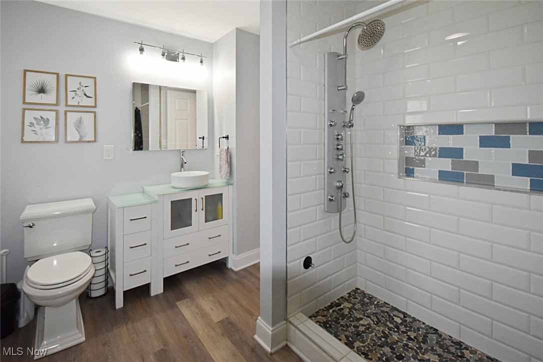 1388 Ford Road Lyndhurst, OH 44124 - Photo 18 of 39 Bathroom featuring vanity, a tile shower, toilet, and hardwood / wood-style floors