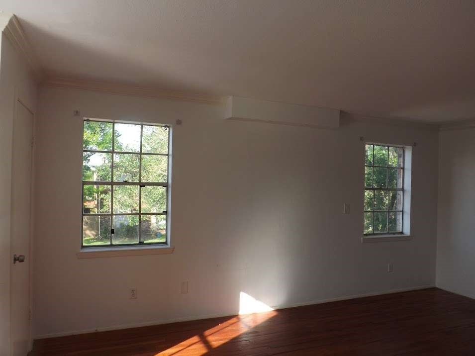 7936 Grove Ridge Drive Houston, TX 77061 - Photo 8 of 11 an empty room with wooden floor and windows
