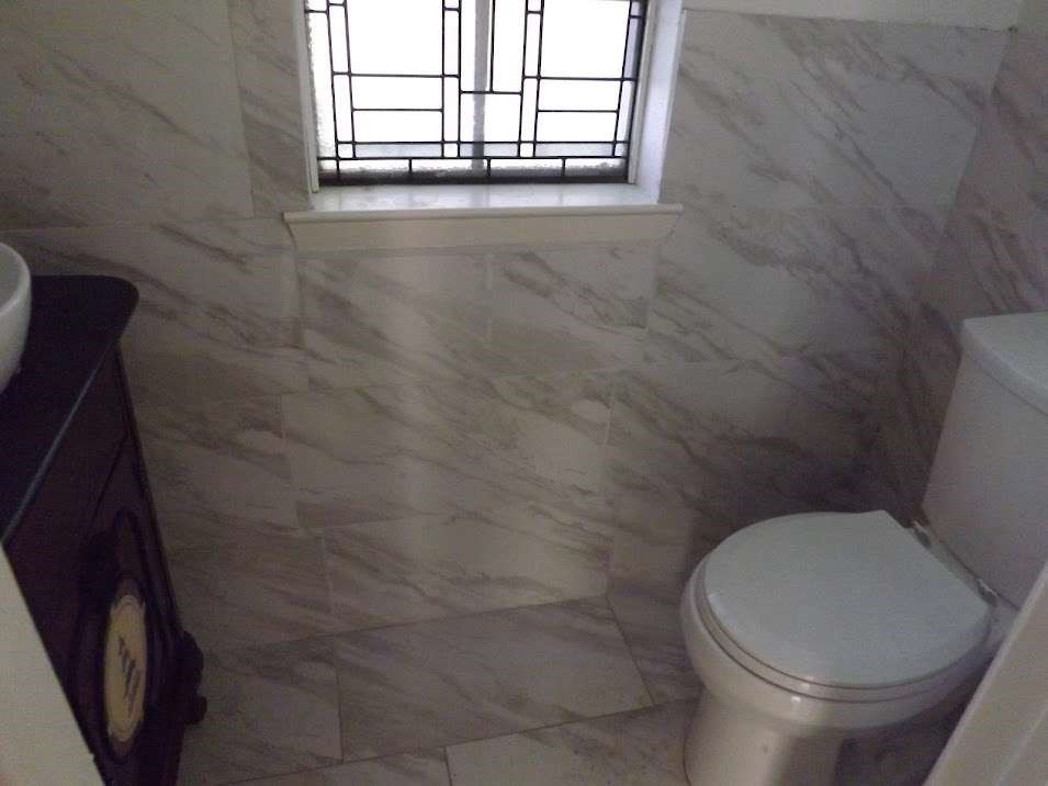 7936 Grove Ridge Drive Houston, TX 77061 - Photo 9 of 11 a white toilet sitting in a bathroom next to a window