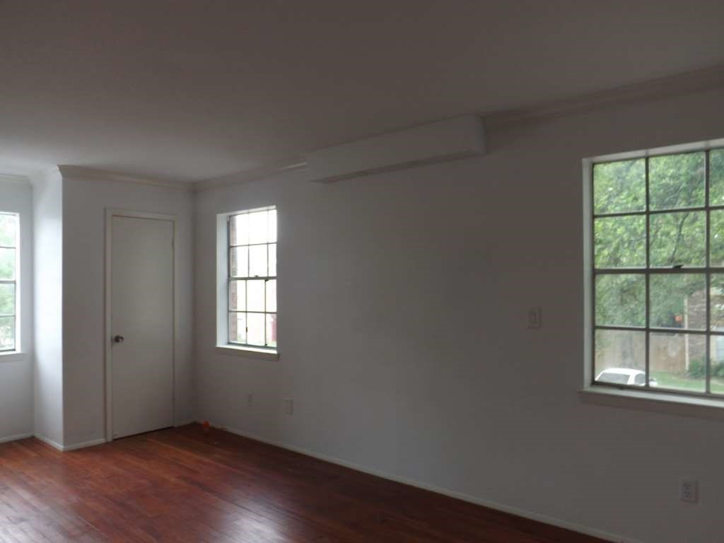 7936 Grove Ridge Drive Houston, TX 77061 - Photo 10 of 11 a view of an empty room with wooden floor and a window