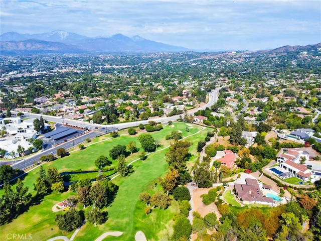 an aerial view of residential houses with outdoor space and trees