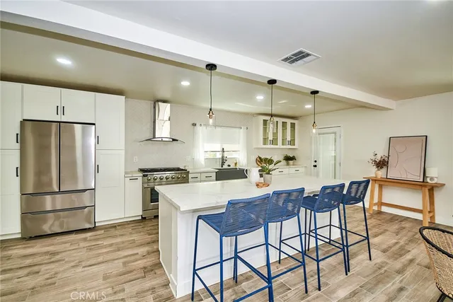 a kitchen with stainless steel appliances a table and chairs in it