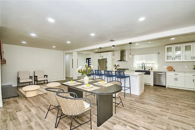 a kitchen with a dining table chairs stove and white cabinets