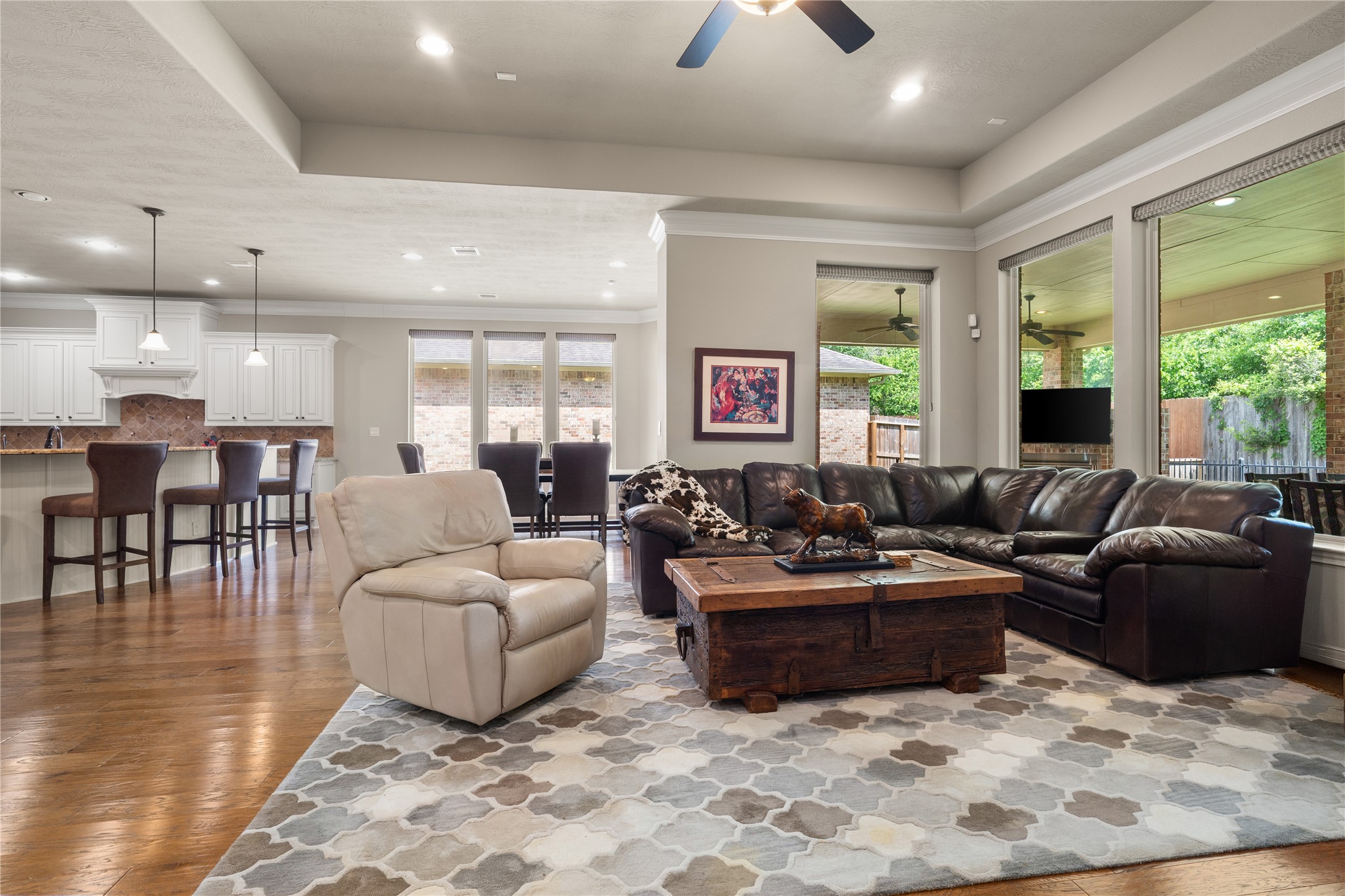 19813 Cullen Ridge Drive Porter, TX 77365 - Photo 17 of 44 This inviting family room, bathed in natural light through expansive windows, seamlessly blends warmth and elegance, creating the perfect setting for relaxation and entertainment.