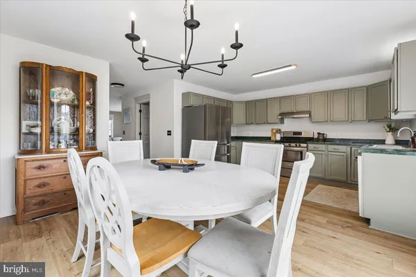 a kitchen with granite countertop a sink cabinets stainless steel appliances and a window
