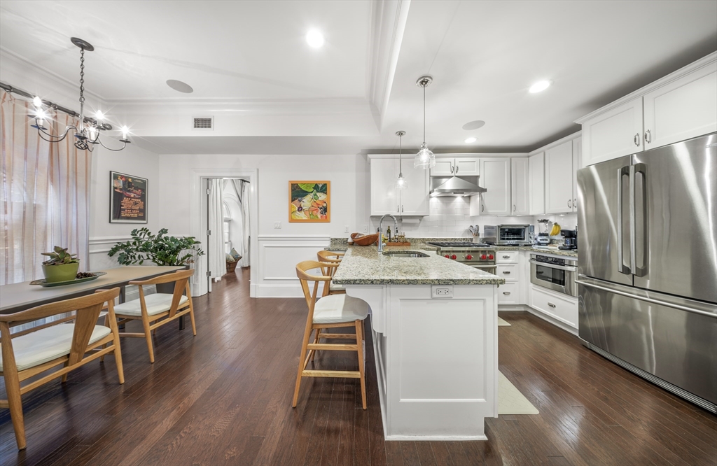616 East 4th Street, Unit 301 Boston, MA 02127 - Photo 2 of 13 a kitchen with kitchen island a white counter top space a sink stainless steel appliances and cabinets