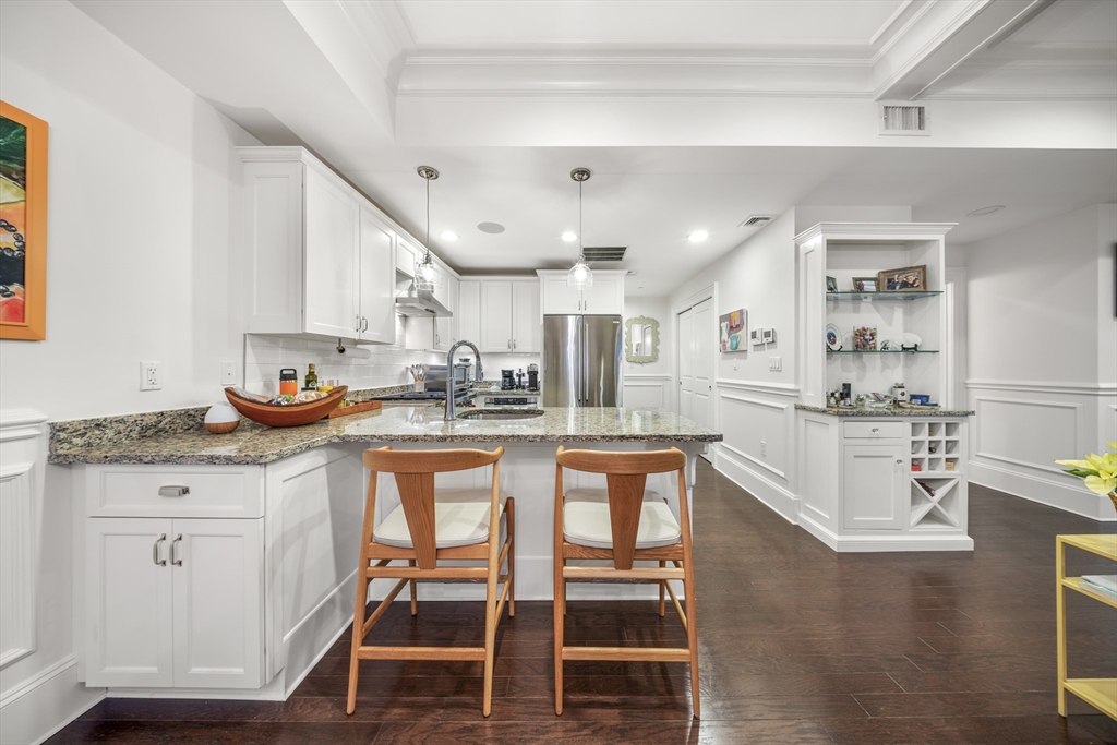 616 East 4th Street, Unit 301 Boston, MA 02127 - Photo 3 of 13 a kitchen with stainless steel appliances granite countertop a stove and white cabinets