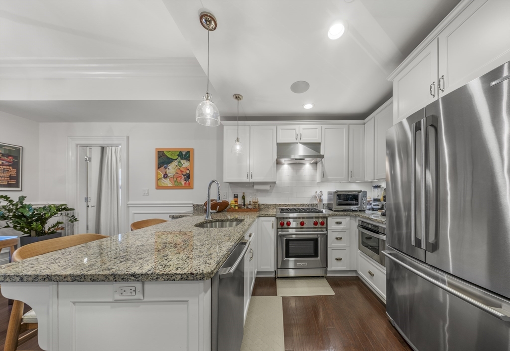 616 East 4th Street, Unit 301 Boston, MA 02127 - Photo 5 of 13 a kitchen with stainless steel appliances granite countertop a sink stove and refrigerator