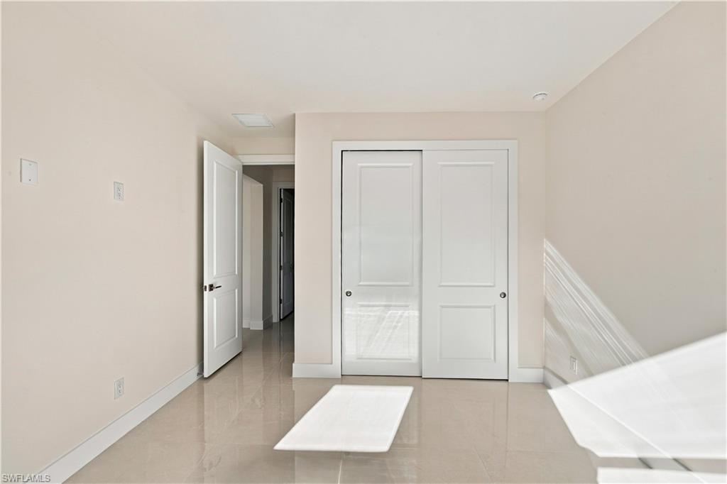 183 5th Street Southwest Naples, FL 34117 - Photo 18 of 40 Neutral wall finishes, recessed lighting, white trim, sliding panel doors, and tile flooring