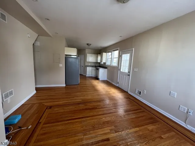 a view of empty room with wooden floor and window