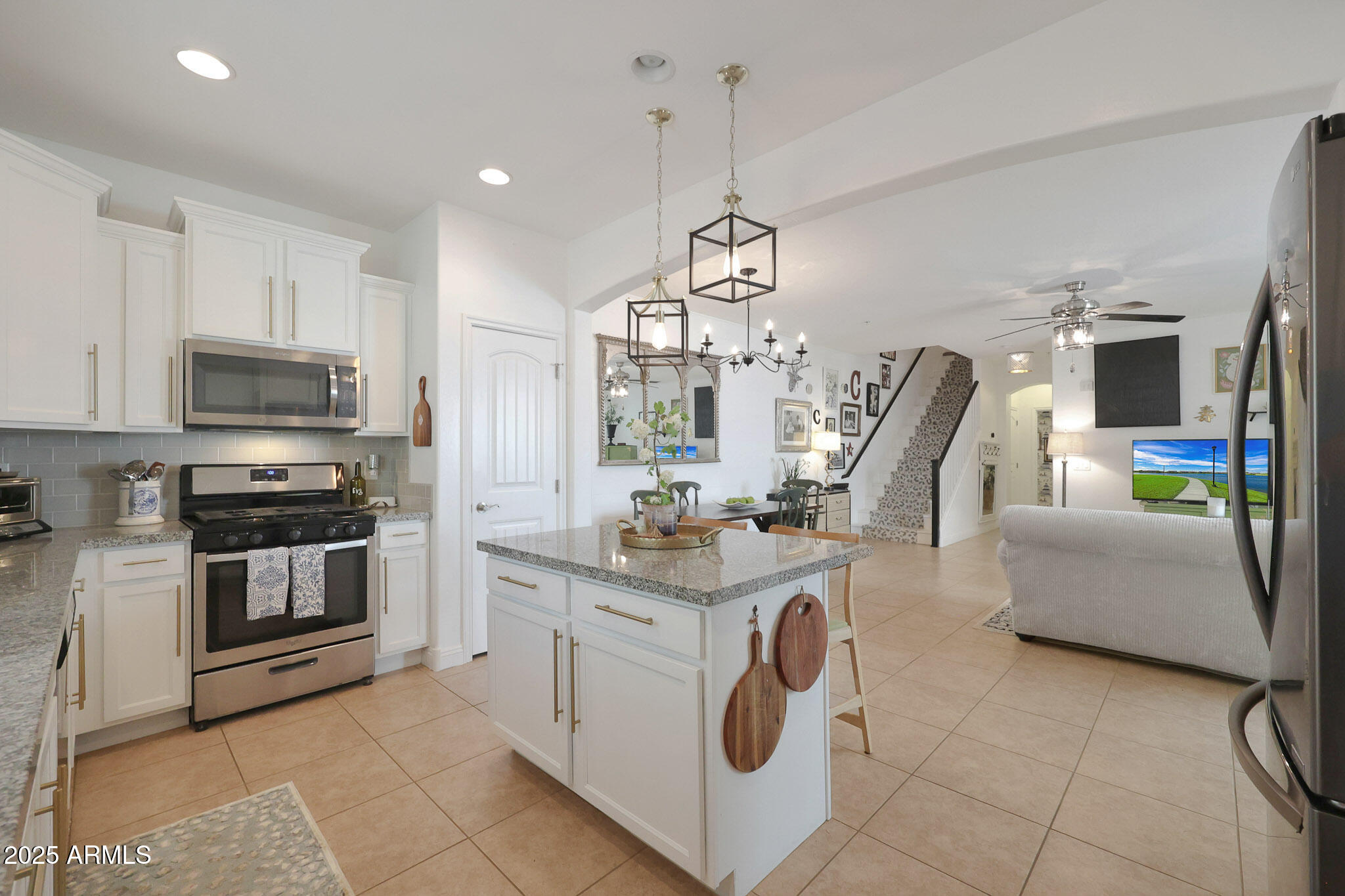 20563 West White Rock Road Buckeye, AZ 85396 - Photo 11 of 44 a kitchen with kitchen island granite countertop a stove a sink and a microwave