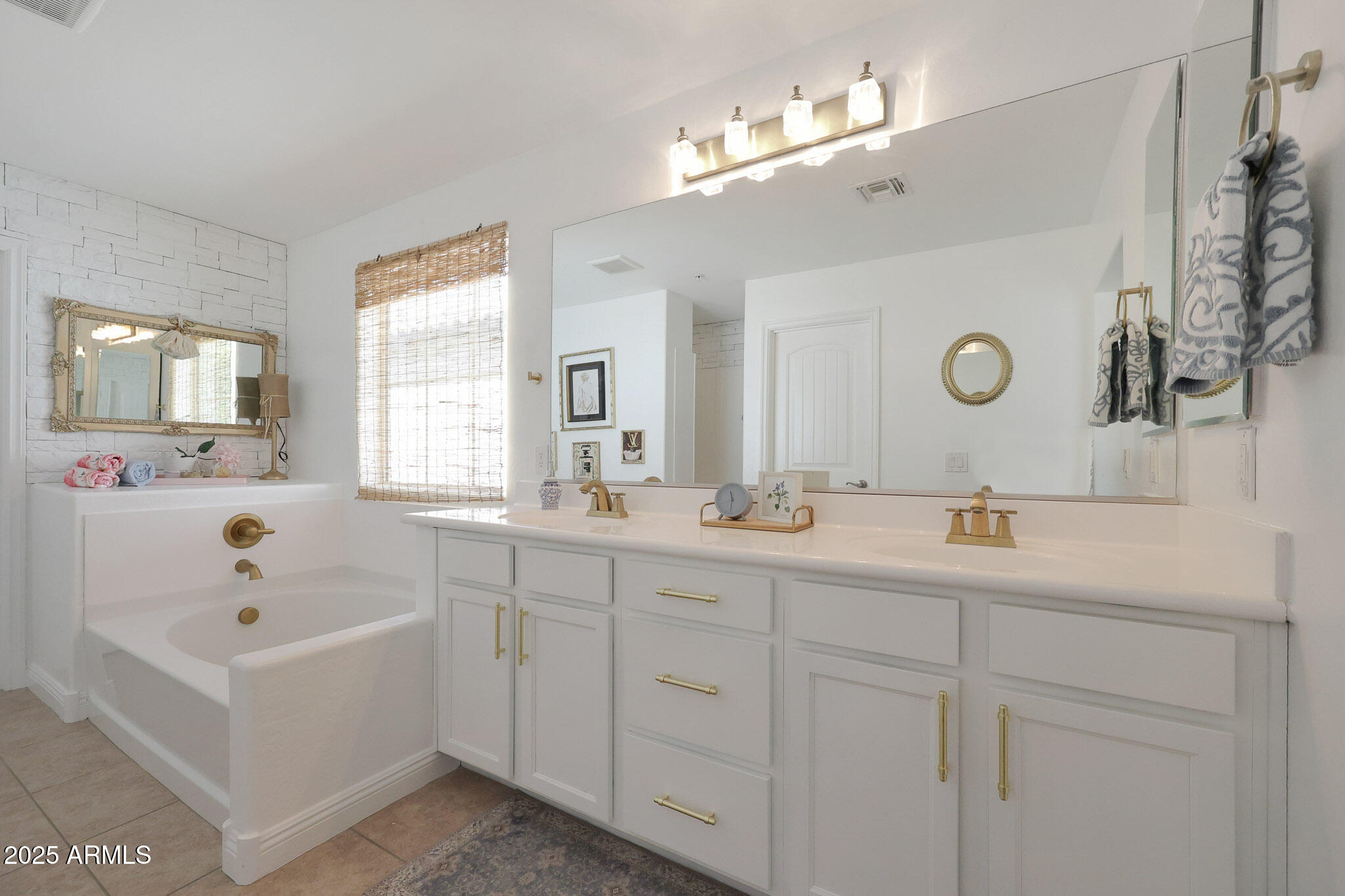 20563 West White Rock Road Buckeye, AZ 85396 - Photo 27 of 44 a bathroom with a tub a double vanity sink and mirror