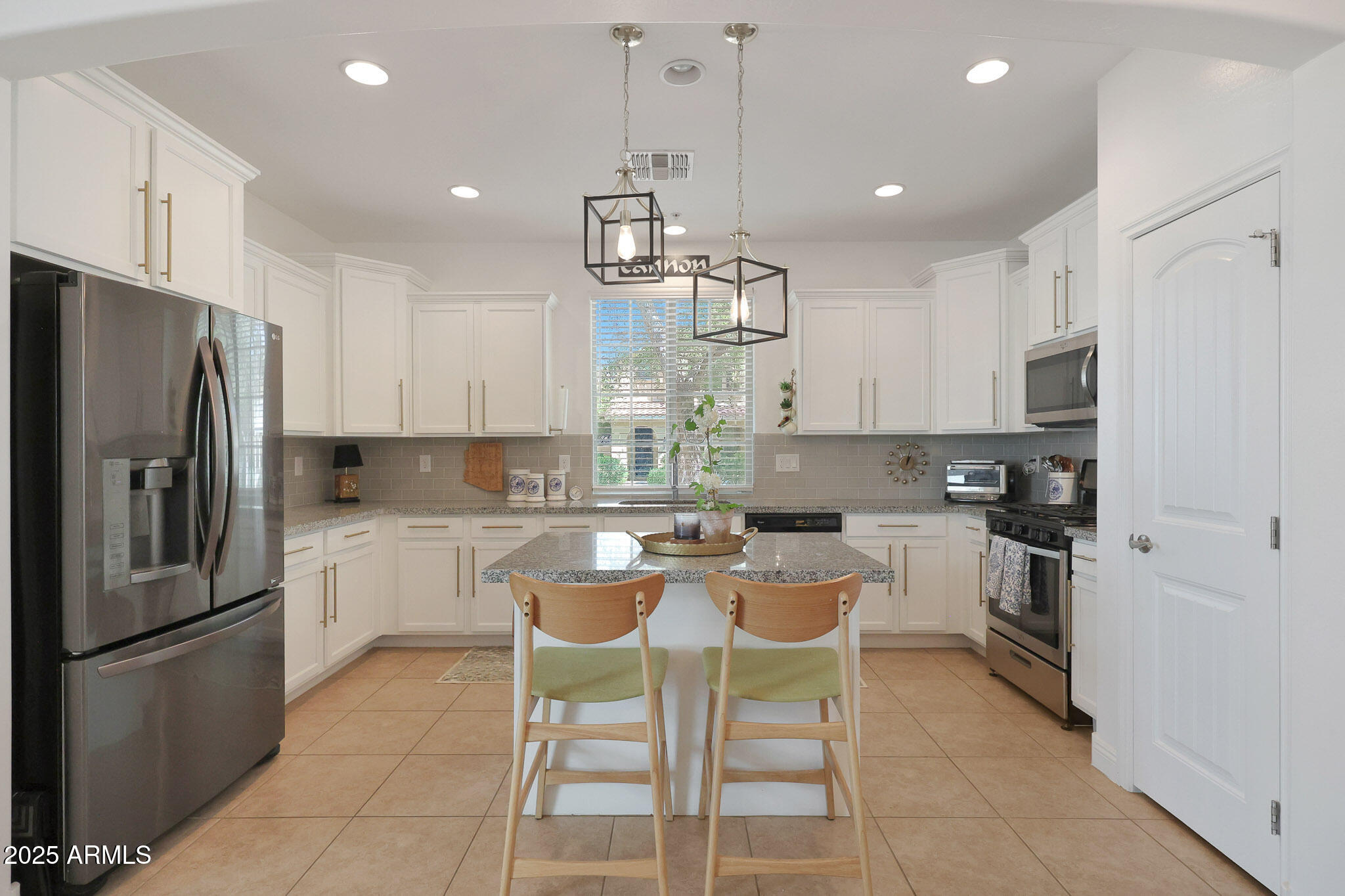 20563 West White Rock Road Buckeye, AZ 85396 - Photo 8 of 44 a kitchen with stainless steel appliances granite countertop a sink a stove a refrigerator cabinets and chairs
