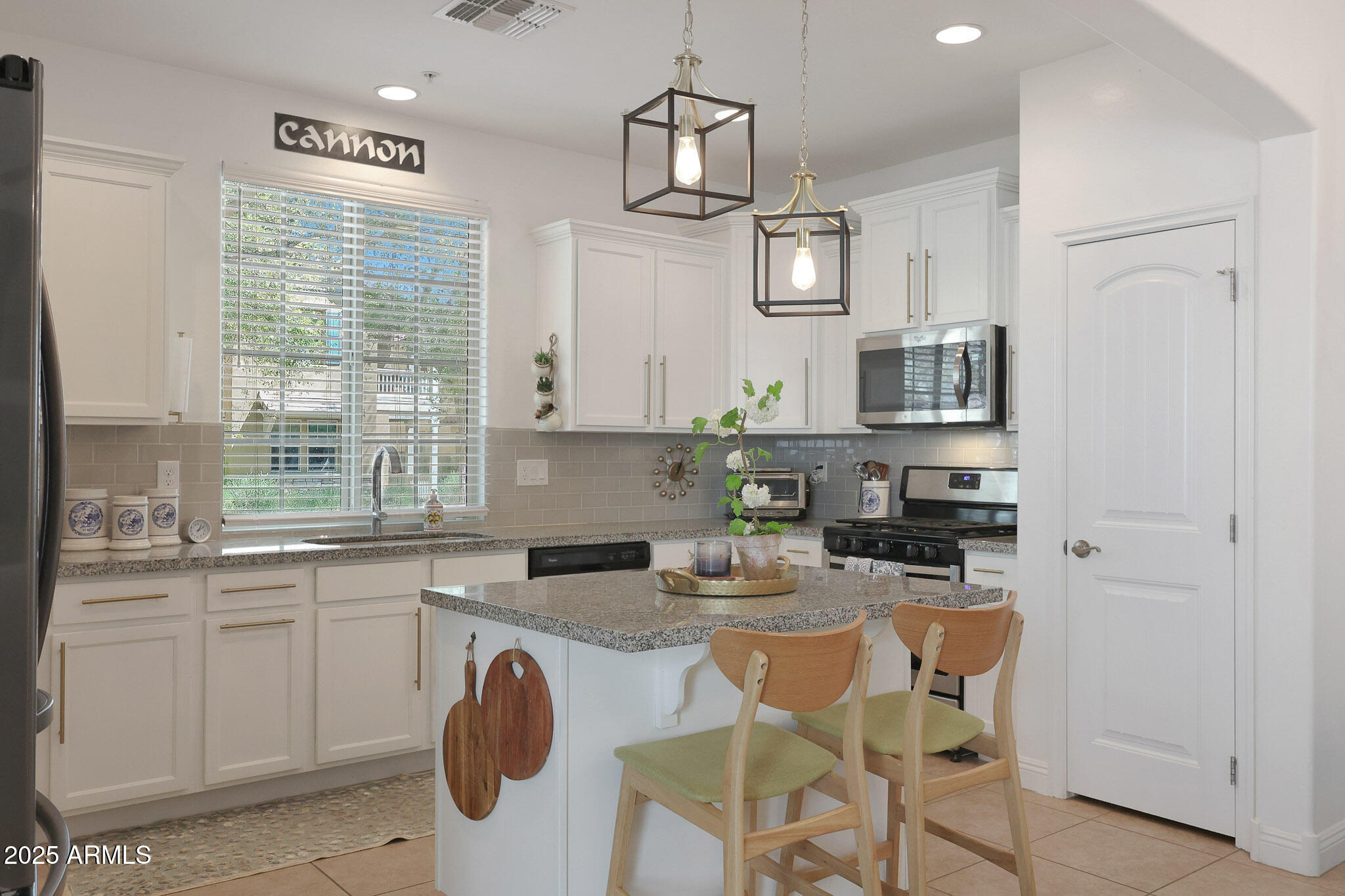 20563 West White Rock Road Buckeye, AZ 85396 - Photo 9 of 44 a kitchen with stainless steel appliances granite countertop a sink a stove cabinets counter space and a window
