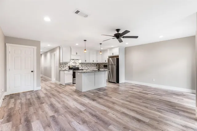 a view of kitchen with granite countertop cabinets and refrigerator