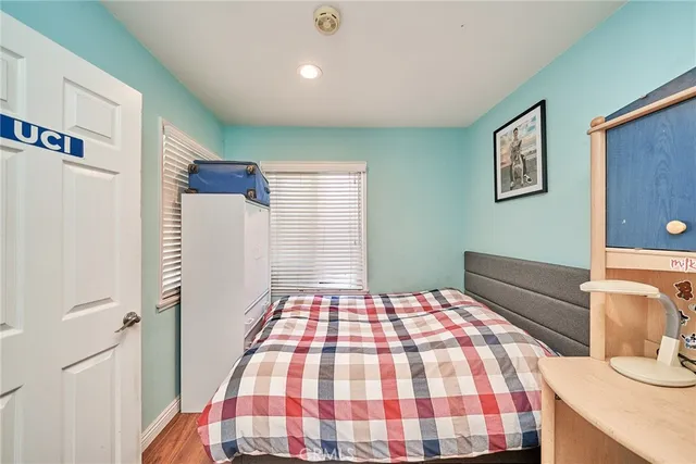 a bedroom with a bed and a lamp on dresser