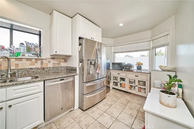 a kitchen with white cabinets and white appliances