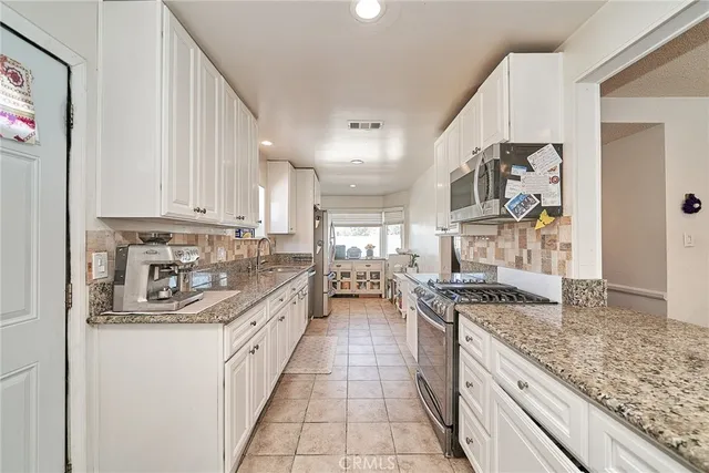 a kitchen with stainless steel appliances granite countertop a stove and a sink